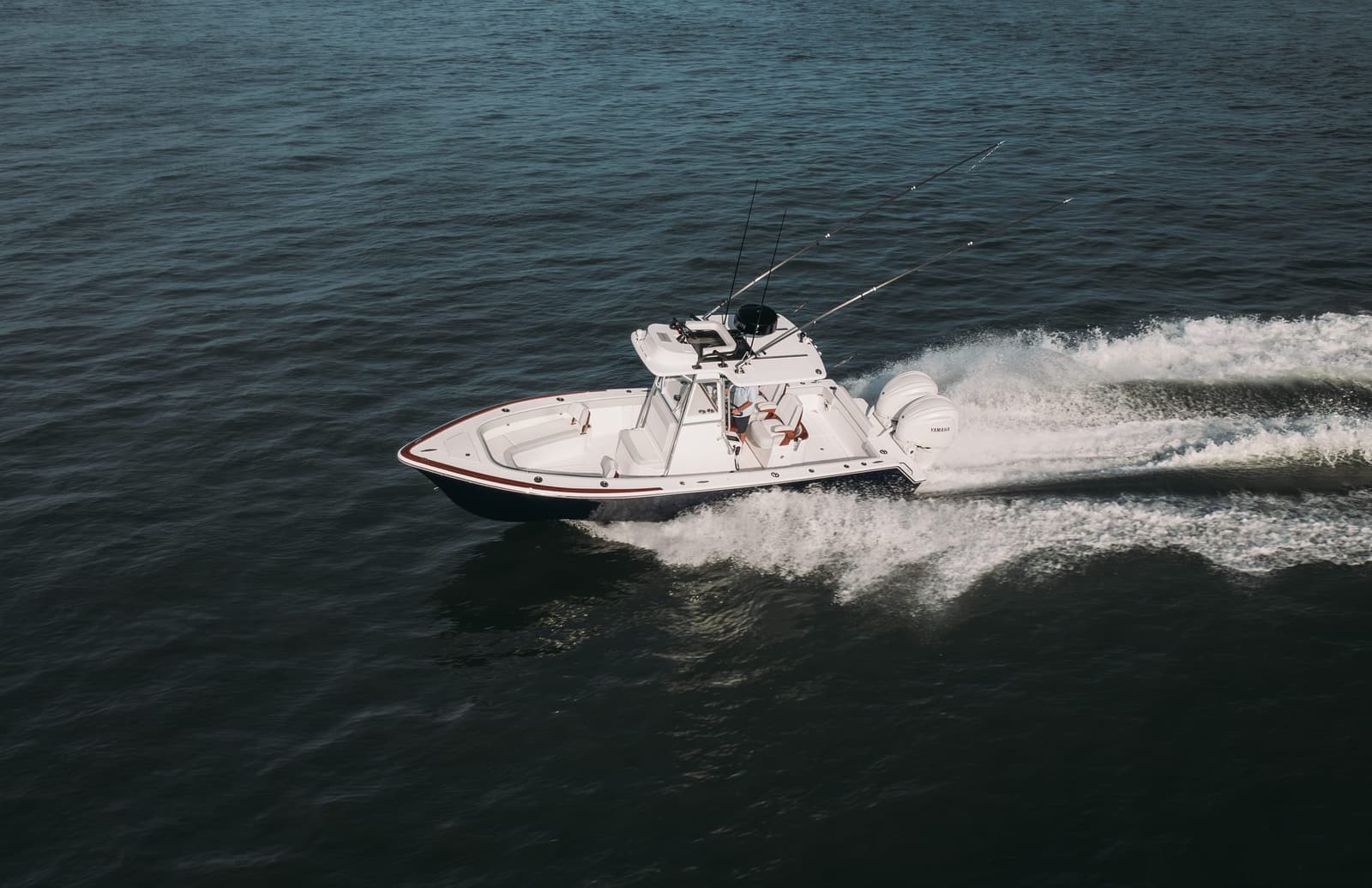 Aerial view of a white Stuart 27 carving a wake offshore