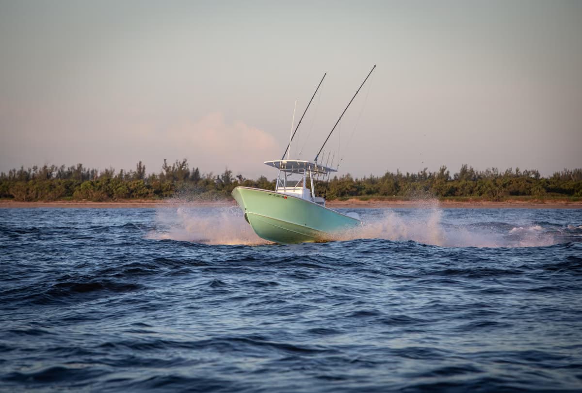 Seafoam green Stuart center console running at speed near the shoreline