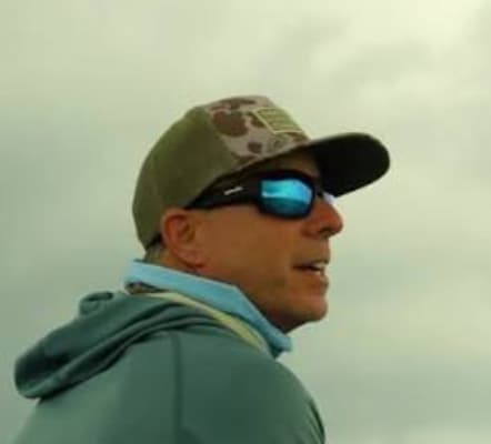 Portrait of a Stuart Boatworks team member in a cap and sunglasses on the water
