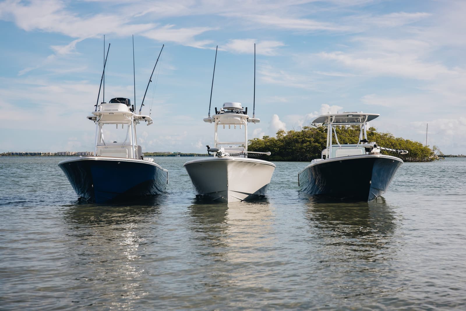 Three Stuart center consoles anchored side by side near a mangrove island